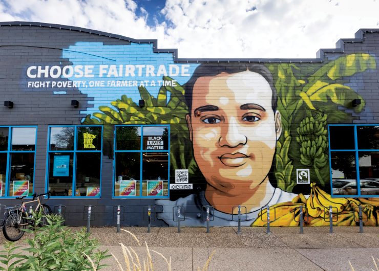 Vibrant Minneapolis mural by Reggie LeFlore featuring Fairtrade banana farmer, Johnny, along with bananas and banana trees.