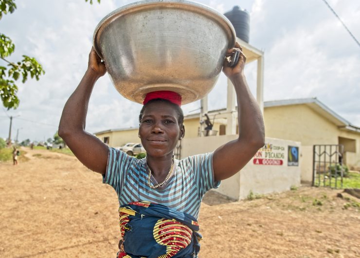 Woman in Cote d'Ivoire carries water from well built with Fairtrade Premium