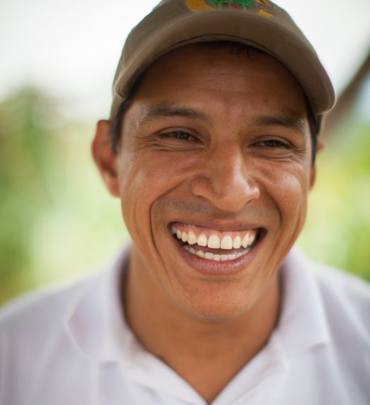 Fairtrade coffee producer in Colombia smiles at the camera.