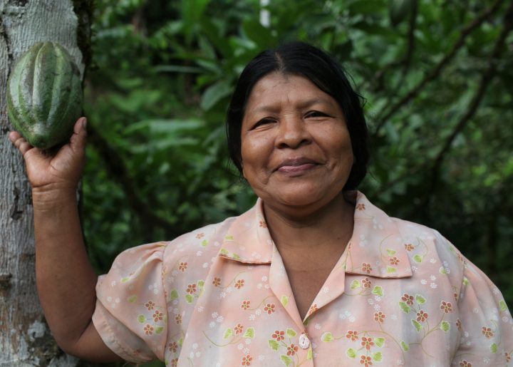 woman holding up cocoa pod