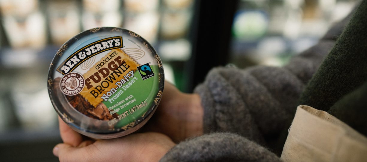 Shopper holds Ben & Jerry's non-dairy ice cream pint in an organic market.