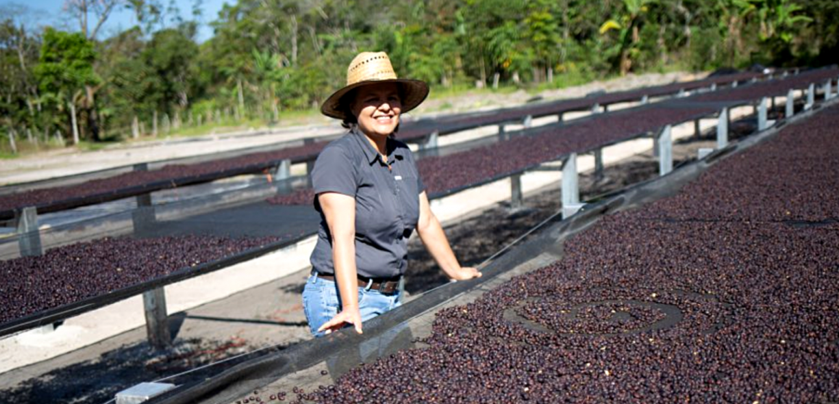 Miriam the cocoa farmer, posing next to coffee beans