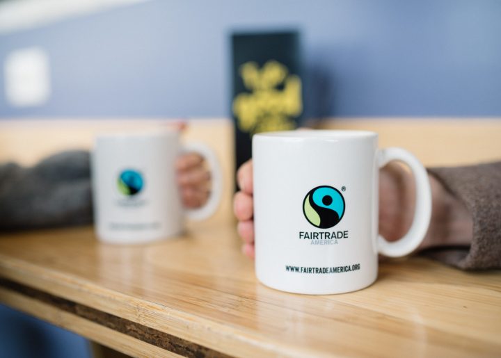 Two mugs rest on a wooden counter at an organic market.