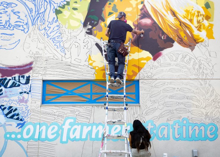 Artists in Austin, Texas creating a mural of 3 Fairtrade farmers at the Wheatsville Co-op.