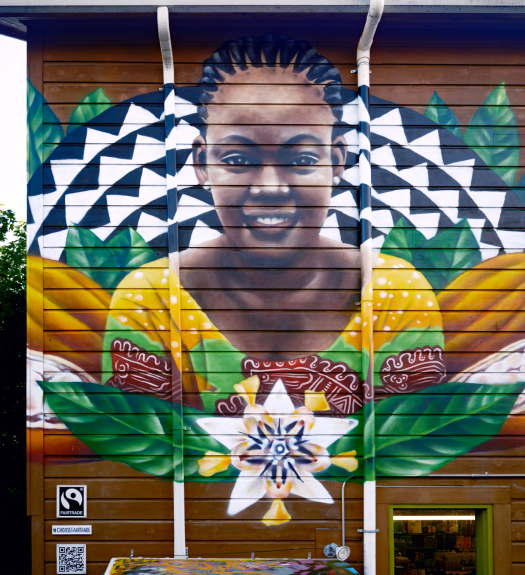 Vibrant mural of Deborah Osei-Mensah depicting cocoa pods and flowers. This mural can be found at the People's Food Co-op in Portland, Oregon.