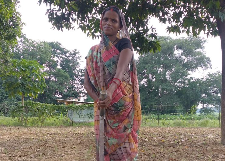 Ranjana Maurya with a farming tool in a field