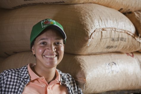 Stefany Parra of Conacado in Dominican Republic in front of bags of coffee