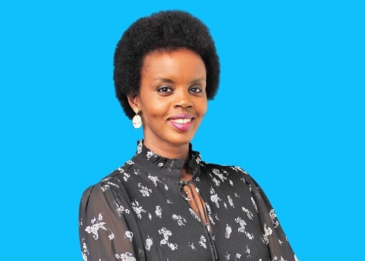 Sandra Uwera poses in front of a blue background.