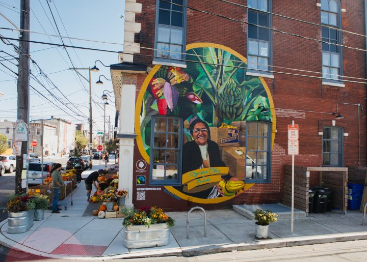 Mural of Ecuadorian banana farmer, Mariana Cobos, painted by Betsy Casañas on the side of Riverwards Produce in Philadelphia, PA.
