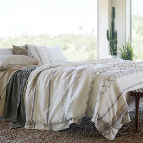 A scenic bedroom with Earth-toned bedding linens.