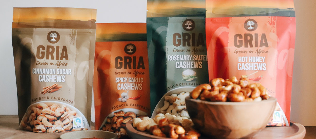 A display of four flavors of GRIA Fairtrade cashews: cinnamon sugar, spicy garlic, rosemary salted and hot honey.