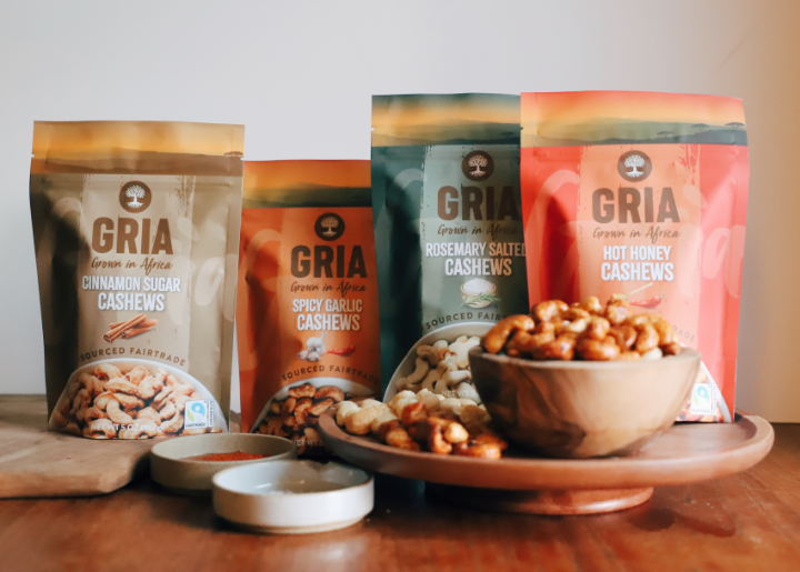 A display of four flavors of GRIA Fairtrade cashews: cinnamon sugar, spicy garlic, rosemary salted and hot honey.